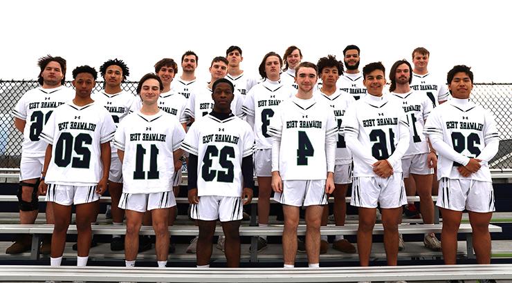 The 2024 Delaware Tech Lacrosse team standing on the bleachers in their uniforms